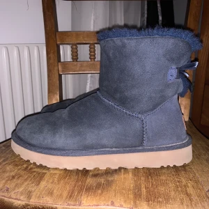 Mörkblåa uggs - I ett fint skick. Knappast använda. Rosett baktill. Nypris 2300kr på Mathilde. Frakt tillkommer eller så möts jag upp i Stockholm. 