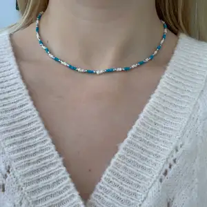 Blått, vitt & silvrigt pärlhalsband med små pärlor🤍🦋💙💫⭐️🥺🤩 halsbandet försluts med lås och tråden är elastisk 