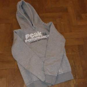 Grå hoodie från Peak Performance i storlek 160 cm. Den är i nyskick utan några synliga tecken på skador eller användning trots att den är ca 10 år gammal. Den är med andra ord väldigt svår att få tag i nuförtiden. 