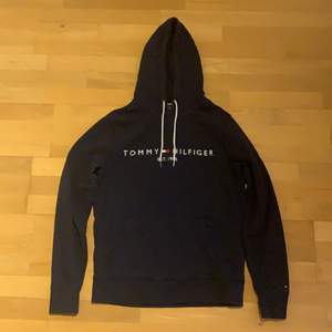 En marinblå Tommy Hilfiger hoodie, ett år gammal, inte sliten, knappast använd.