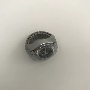 Cool ring klocka - Cool ring klocka. Klockan är ur funktion men borde fungera om man byter batteri på den. Den är 19mm men som ni ser på bild 3 går den att töja så passar dem flesta. Är inte i ekat silver men väldigt bra kvalitet. Köparen står för frakten. 