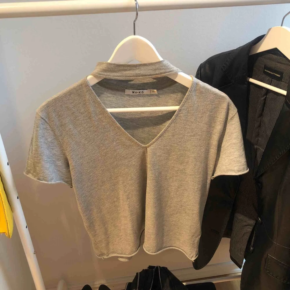 Säljer denna gråa t-shirt från NAKD! Tröjan är i storlek  XXS men passar även någon som har uppemot S i storlek . T-shirts.