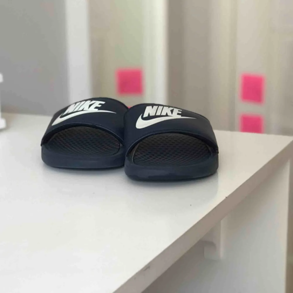 Ett par marinblå Nike tofflor. Har använts som inneskor, därför inte så slitna. Säljs för 150kr. Betalning sker via swisch :)) köparen står för frakt. Övrigt.