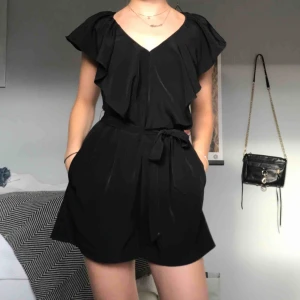  - Svart playsuit från H&M i fint blus-material! Har en kedja i ryggen och ett band i midjan vilket gör att den funkar på XS också trots att det är en S. Super bra skick, helt orörd. 