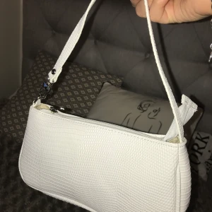 Vit baguetteväska - Jag säljer den här vita baguetteväskan👜🤍✨ Den är ganska liten men perfekt att ha under armen. Skriv gärna bud i kommentarerna 💕 Vill gärna sälja den snabbt så hör av dig ifall du är säker på köpet.