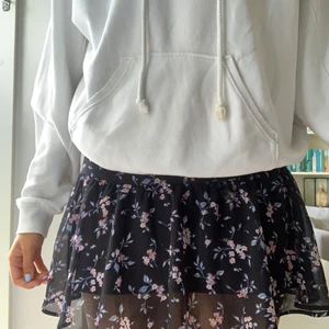 Svart volangkjol med blommor🌸 - Svart volangkjol med blommor från hm. Varsamt använd och inga skador eller slitningar. Säljes då den är alldeles för kort på mig 175cm💕 