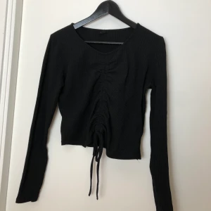 Tröja med detalj - Snygg tröja med snördetalj i storlek M. Använd 2-3 gånger och är i fint skick. Köpt på Gina Tricot. Hämtas i bro eller skickas.