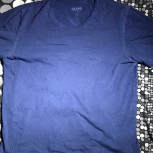 Blå Hugo Boss T-shirt - ✨En Fräsch och snygg blå Hugo Boss T-shirt!🙌🏼😍 Den är nästan helt oanvänd och är i fint skick!🤩     👕Den är skön, snygg och passar till det mesta!😇  📤köparen står för frakt!🚚 