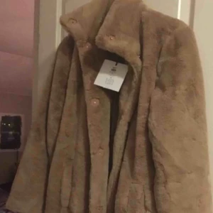  - Helt ny fuskpälskappa. Strl 38, aldrig använd. Sjukt mysig, perfekt som vinter/höstjacka
