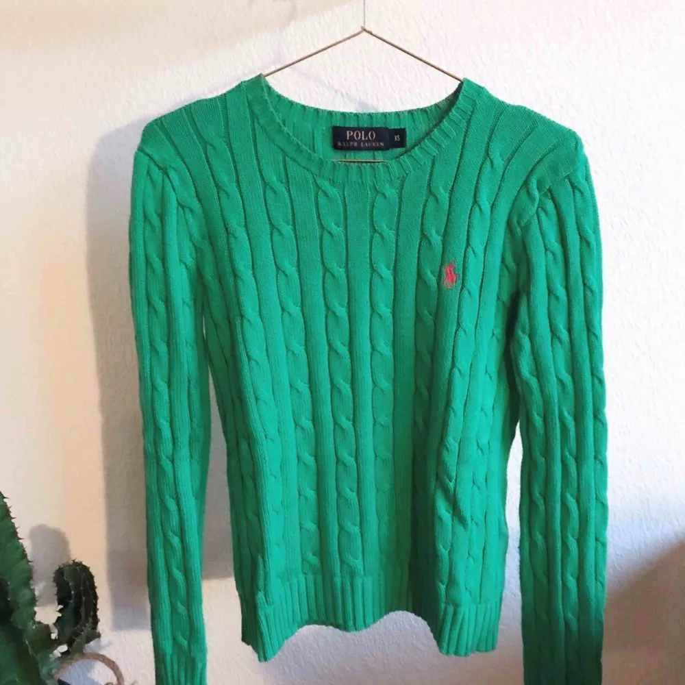 Kabelstickad tröja från POLO RALPH LAUREN. Grön med röd logga, rundad halsringning. Mycket fint skick. Kommer från ett djur- & rökfritt hem. . Tröjor & Koftor.