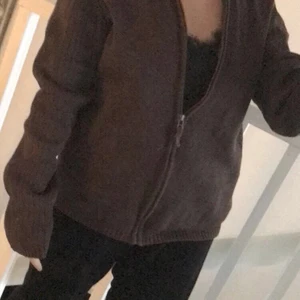 Brun kofta - En brun kofta med olika detaljer från East West i storlek L är själv en S och koftan sitter oversize på mig som på bilderna. Varm och skön nu i vinter och jätte enkel att styla:)