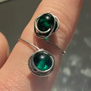Handgjord ring av pläterad ståltråd med två gröna pärlor. Denna ring är fullt justerbar! 