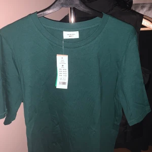 T-shirt  - En supersnygg mörkgrön T-shirt från Gina tricot, helt oanvänd! Nypris är 149 kr och jag säljer för 80 kr + frakt🤍✨
