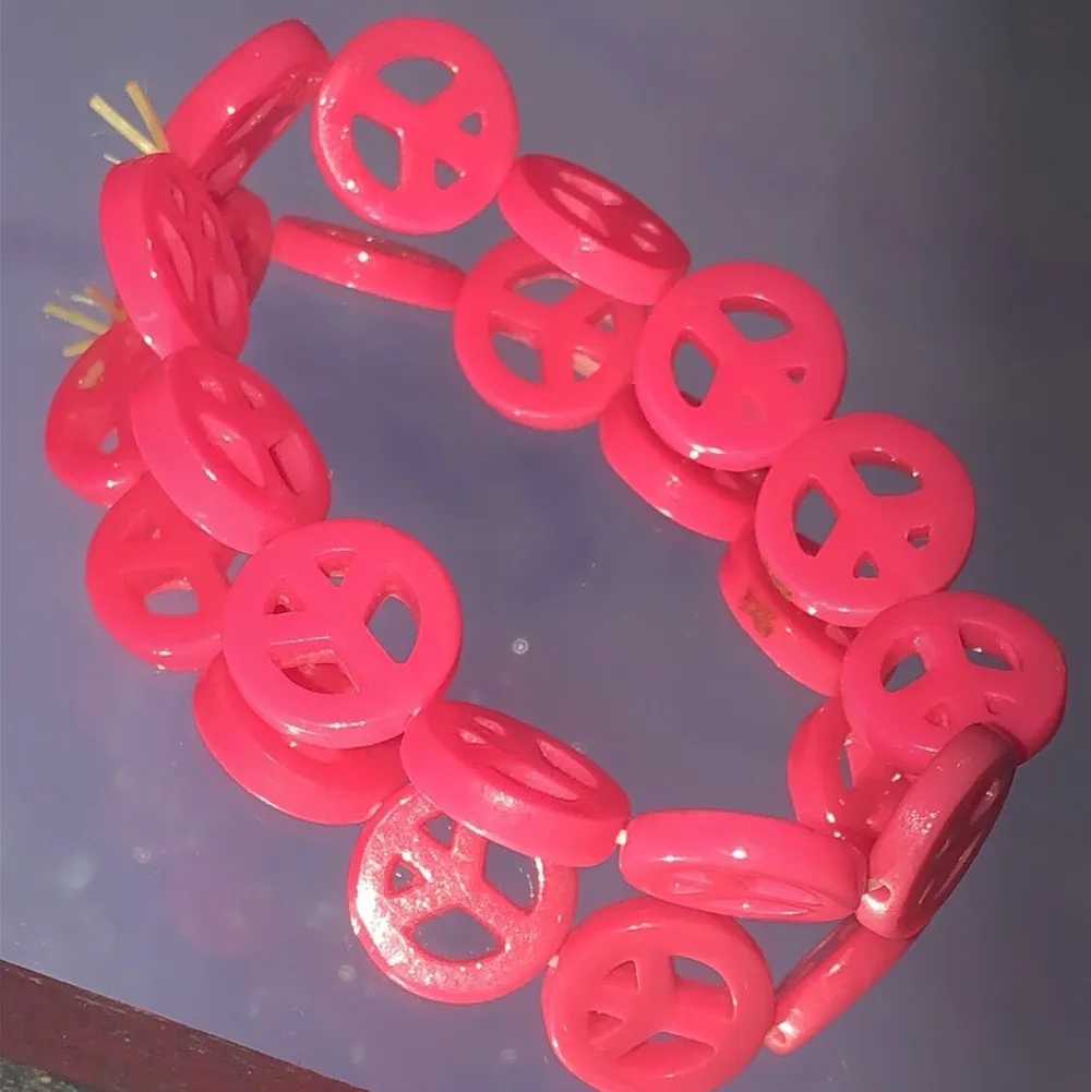 Två armband med peace formar neon rosa och neon orange. Säljer 20st men båda för 30.. Accessoarer.