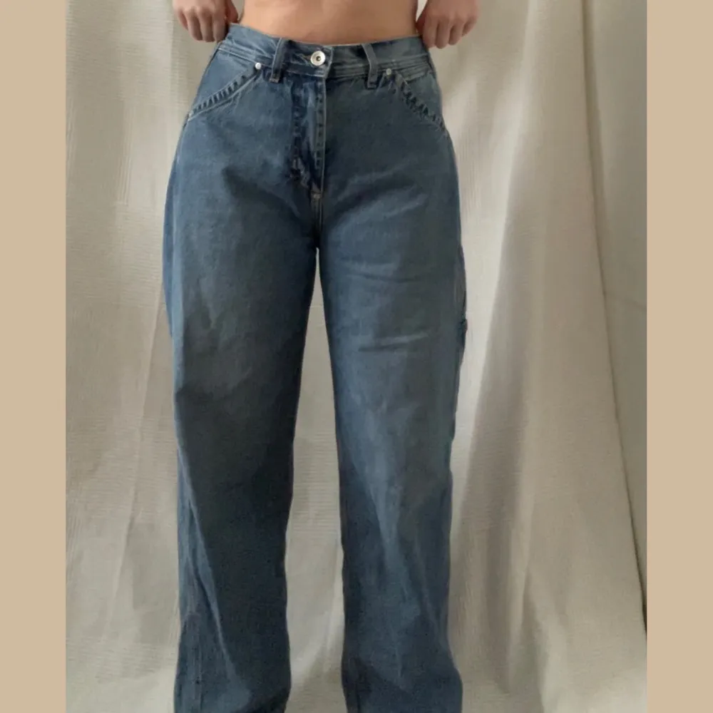 mycket snygga oversized jeans från weekday x lee. de är högmidjade. detaljer på högra benet med fickor. visas på en M som är 165 cm lång. i nyskick! nypris 800kr. skriv för fler bilder! . Jeans & Byxor.