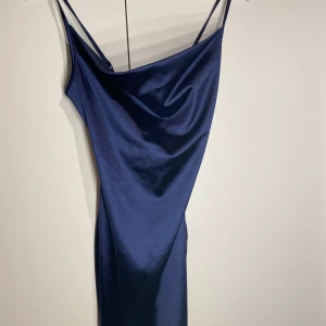 Satin mörkblå figursydd klänning - Den sitter perfekt på kroppen och framhäver kurvorna på kroppen. Den passar även perfekt till festliga tillfällen💙😍😍 Köpt för 250kr men säljs för 180
