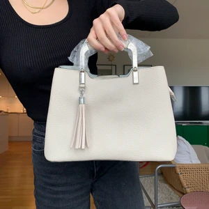 Grå väska  - Jag säljer denna superfina gråa väska (med beige undetoner) som blivit köpt utomlands men sedan aldrig använd. Den är i nyskick. Väskan har på insidan tre stora fack med yttligare små fickor. 💞 köparen står för frakten men jag möter även upp i Lund💞 