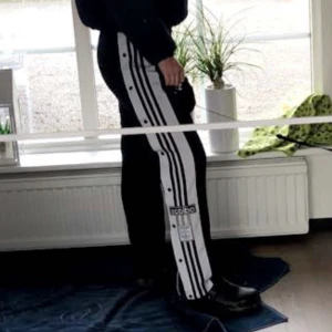 Adidas byxor - Raka byxor med knäppe på sidan och fickor med dragkedja 