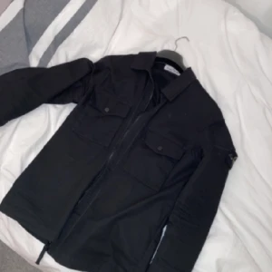 Stone Island Overshirt  - En snygg och stilren overshirt från Stone Island. Tröjan är i storlek M och passar mig väldigt bra i längd, bred och armlängd som är 180 cm. QR kod finns och kan skickas om du verkligen är intresserad, inga fel och köptes för 2999kr ny (kan tänkas att sänka)