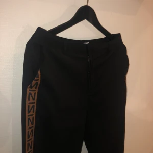 Kostymbyxor - Ett par skit snygga kostymbyxor från NAKD, brun rand på sidan av byxorna! Använd endast ett fåtal gånger.