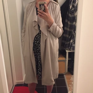  - Snygg tunn kappa med midjeskärp. Sitter jättesnygg på! Härligt fall på tyget. Den har fickor. Storlek 40. 

150kr inkl frakt. 