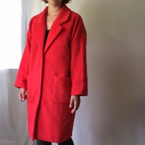  - Orange-röd kappa från monki. Knappt använd! Tre stora knappar och fickor fram. 