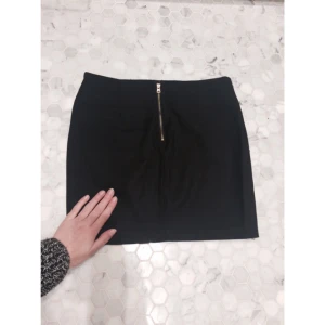  - Svart kort kjol med guld dragkedja. Forever 21, storlek S men snarare en svensk XS.