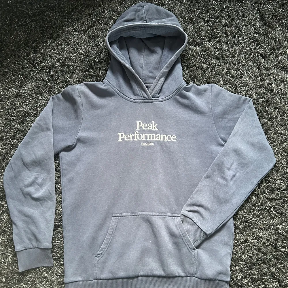 Peak Performace hoddie (junior). Använd en del men fortfarande e ganska bra skick. En litet hål vid armbågen men annars inga skador.  Storlek 170 Färg mörk blå . Hoodies.