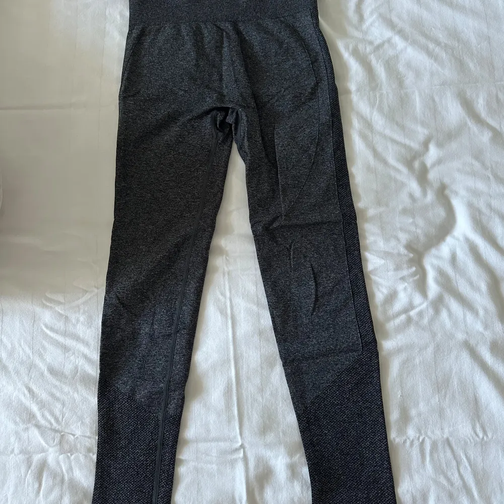 Säljer ett par grå/svarta leggings i storlek S från SHEIN. Perfekta för träning. De har en hög midja och en tight passform som formar ut figuren mer. De har dock en liten skråma på baksidan, som man ser på sista bilden. Syns endast vid knäböj!! 💕. Sportswear.