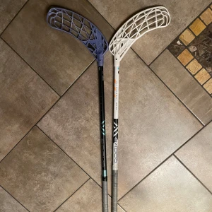 2 oxdog innebandyklubbor - Två innebandy klubbor från oxdog ena är ultralight 29 flex och den andra är sense hes 29 Flex. Den svarta är ungefär 97 cm och den vita är 96 cm då den svarta är kapad från 101 cm båda med avox blad och ett orange fsl finns. Skriv till mig för pris 