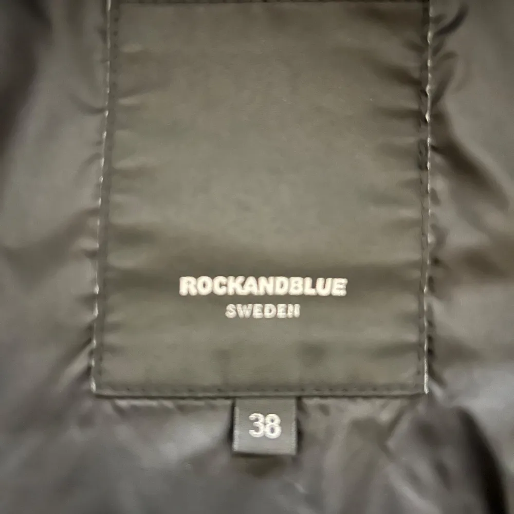 Vinterjacka Rock and blue. Storlek 38. Längd: går till mitten av låret på mig och jag är 1,65. Två dragkedjefickor, två stora innefickor. Lite trasig i inna uterfickan annars är den hel. Fraktkostnaden står du för. . Jackor.