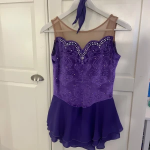 Lila konståknings klänning med diamanter - Lila konståknings klänning i storlek s/xs. Har använts på några tävlingar men fortfarande i väldigt bra skick 