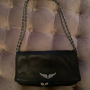 Zadig&Voltaire väska - Zadig & Voltaire väska i Rock Grained Leather, den klassiska modellen. Väskan har avtagbara läder- och metallremmar och kan därför bäras på flera olika sätt t.ex över axeln och kors över kroppen. I jättefint skick! 