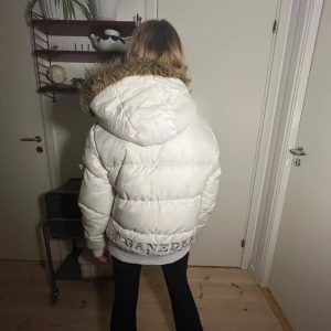 Y2k jacka päls huva - Säljer en snygg vit pufferjacka från Ganeder med en mysig pälsfodrad huva. Jackan saknar dragkedja och har ikoniska 00’s detaljer. Perfekt för kyliga dagar! Kan endast sälja den på min vinted @catwithmustach