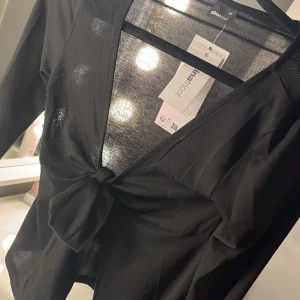 Svart långärmad topp från Gina Tricot - Snygg svart långärmad topp från Gina Tricot med knytning framtill. Oanvänd ! Helt ny bara testad 💞💞❤️🩷 nypris 300kr