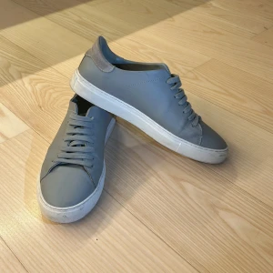 Grå sneakers Axel Arigato - Snygga grå sneakers med vit sula och klassisk snörning. 