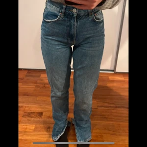 Blå jeans med slits - Snygga blå jeansbyxor med hög midja och klassisk femficksdesign. Perfekta för en avslappnad stil.