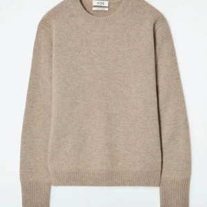 Beige cashmeretröja från COS - Säljer en stilren beige tröja från COS i mjuk cashmere. Tröjan har en klassisk rund halsringning och långa ärmar med ribbade muddar. Perfekt för kyliga dagar! Använd mycket få gånger och säljer för att den är för liten. Nypris 1950 (pris kan diskuteras)