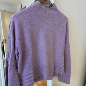 Lila tröja från & Other Stories - Säljer en mysig lila tröja från & Other Stories. Tröjan har en hög krage och långa ärmar med ribbade detaljer vid ärmslut och nederkant. Perfekt för kyliga dagar!