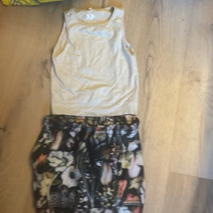 Vit linnetopp från 157 molo kjol - Säljer en vit linnetopp från 157 i storlek 110/120. Perfekt för varma dagar och enkel att matcha med olika stilar. Toppen är ärmlös och har en klassisk design. Säljer en blom kjol från molo i storlek 122/128