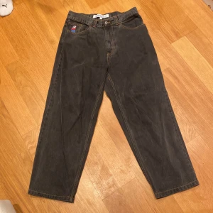 Polar Skate Jeans - Snygga svarta jeansbyxor från Big Boy/Polar med en unik broderad detalj på fickan. Byxorna har en klassisk femficksdesign och är perfekta för en avslappnad stil. De har en normal passform och är tillverkade i slitstarkt material.