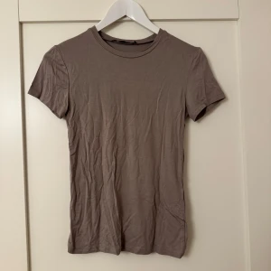 Ljusbrun/beige t-shirt - Basic T-shirt i en liten längre modell från Lager 157. Aldrig använd, endast provad.🤎 Nypris: 80kr