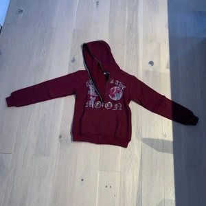 Aumforthemoon - Snygg vinröd hoodie med tryck på framsidan. Den har en dragkedja och en praktisk huva. Perfekt för en avslappnad stil.