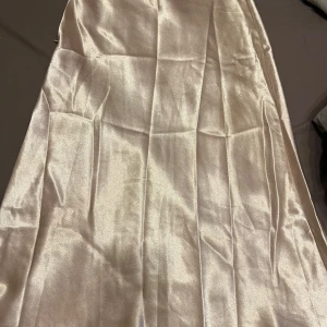 Champagnefärgad klänning från Shein - Elegant champagnefärgad klänning från Shein i ett glansigt material. Perfekt för speciella tillfällen med sin stilrena design.