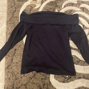 Svart offshoulder topp - Snygg svart offshoulder topp med långa ärmar från newyorker. Perfekt för en stilren look. Passar bra till både jeans och kjol och för en elegant look. Den är använd 1 gång. Nypris 250kr