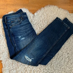 Blå slim jeans från Jack & Jones - Säljer ett par snygga blå slim glenn jeans från Jack & Jones. De har en klassisk femficksdesign och slitna detaljer för en trendig look. Perfekta för en avslappnad stil.