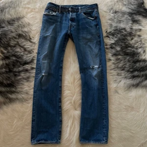 Levis 501 av äldre modell - Levis 501 i en äldre modell vilket föredras enligt många över de nyare modellerna. De är av grovt och styvt material vilket gör att de sitter rakare och bättre. Storlek 32.34, modellen är 182.  Hör av dig vid frågor eller funderingar. MVH. Båstad pluggen.