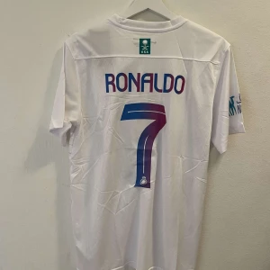 Ronaldo Al Nassr fotbollströja  - Helt ny re-plika fotbollströja från Al Nassr med Ronaldo på ryggen. Storlek Medium.
