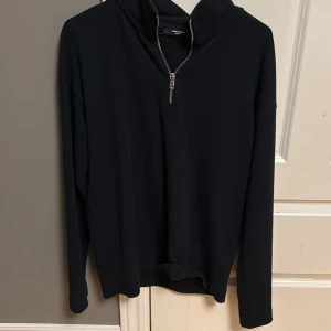 Mörkblå tröja med dragkedja från Jack & Jones - Snygg svart quarterzip från Jack & Jones med dragkedja vid halsen. Perfekt för en stilren look. Tröjan har långa ärmar och en bekväm passform.