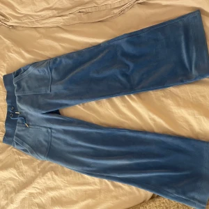 Juicy byxor (uppsydda) ❤️ - Snygga blå juicy byxor med elastisk midja och praktiska fickor med knappar baktill. Byxorna har en broderad logga framtill och är tillverkade i ett mjukt material som ger en bekväm passform. Jag köpte byxorna på raglaydy för 1100kr. Det var ett tag sedan och jag var rätt så kort då, jag sydde då upp byxorna typ 10cm därför är dom kortare. Jag bad även skräddaren att sy sömmarna exakt som dom var innan och det gjorde han. Man ser inte öns att dom är uppsydda om man inte tänker på längden. ❤️❤️